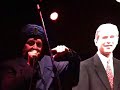 gerald casale, backed by the spudboys at the total devotional at beachland ballroom in cleveland on 8-25-07, as jihad jerry, interacts musically with an effigy of president george w. bush.