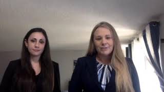 Two women law students in suits discuss the Representation in Mediation Competition