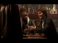 a dvd pirate sells his wares to a group of mates in a pub. they ask him for 