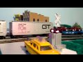 Lionel Grand Trunk Western GP7 and Switcher roll through the grade crossing with heavy freight.