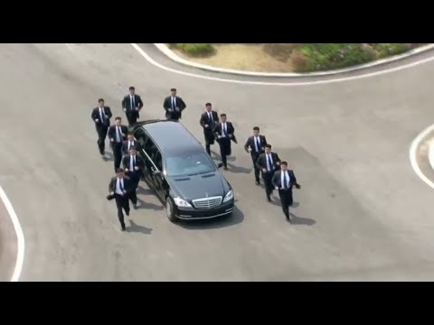 Bodyguards joggen im Gleichschritt neben der Limousine von Kim Jong-un