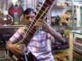 Sitar saleman plays in a store in Agra India