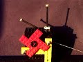 Closeup of working dead-beat (Graham) pendulum clock escapement made with Lego. The transmission ratio to the (recoil-less) seconds hand is 9:1 (1/3*1/3). The pendulum length (72 cm) exceeds the theoretical value 9.81*(4*9*2*pi/60)**-2 (69 cm) because it's center of mass lies above the bob.Part of series W1 thru W12