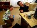 Two nameless boys are laughing on the floor in the school