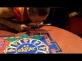 Monaco tibetano mentre crea un mandala con la tecnica tradizionale