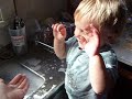 Toddler playing with dishwater bubbles