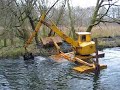 Floating Digger cleaning a river buttom for bottles and mud