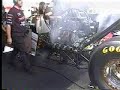 A closeup, steady shot of NHRA Top Fuel Driver David Grubnic warming up his car in the pits.