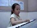 Chinesinha adorável tocando Tico-tico no Fubá ao teclado