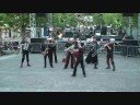 v�tus de noir et rouge, semblant sortir dun monde et dune p�riode inconnue, les 8 musiciens de la goutte au nez envahissent sc�nes et places publiques, tels des dandies survolt�s. les sir�nes hurlent, les cuivres sonnent, laccord�on se d�chire, les voix se tordent, comme pour annoncer � la population une explosion de d�mence musicale. a travers des sonorit�s percutantes, cuivr�es, irr�elles, cette fanfare atypique immerge le public dans un univers urbain, � la fois myst�rieux et fr�n�tique. a mi-chemin entre le rock d�structur� de frank zappa et la bande originale dun film fantastique, ces 8 activistes un brin �nerv�s, surprennent par loriginalit�, l�nergie et la folie de leurs compositions. le spectateur est alors emport� dans un univers musical, m�lant rythmiques massives et atmosph�res lunatiques, qui d�soriente et stimule limaginaire.