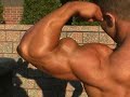 Bodybuilder Ralph Teich poses biceps outdoors