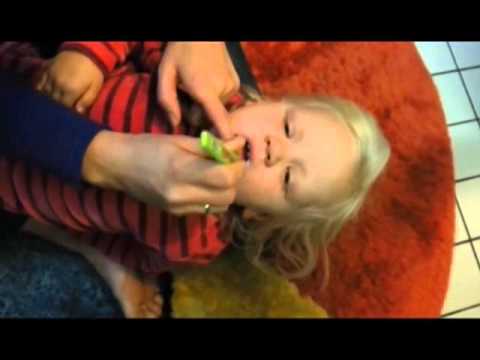 Eltern putzen die Zahne ihres Kindes sauber (3 Jahre alt)