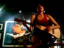 Playing guitar while riding her bicyle on a trainer.