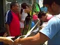 Tying ballons, presents, and streamers on the braided palm tree, or Umisha, to be set up and cut down at Carnaval.