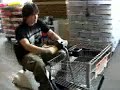 Tak Sakaguchi Rides an Auto-Cart in a Supermarket.