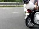 Indian guy texting on his cellphone while riding motorcycle in the middle of busy freeway?