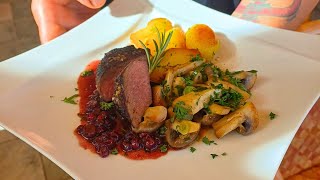 Medaillons aus der Hirschkalbskeule auf Preiselbeer-, Rotweinsauce, gebratene Champignons und Rosmarinkartoffeln