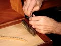 more harpsichord stuff @ www.hpschd.nu
carey beebe demonstrating string winding on an historic tuning pin.
the wire must be firmly locked on the pin to prevent it slipping at pitch.
the string is pulled tight from the hitchpin loop and the relevant tuning pin selected. a loose spiral of wire is wrapped down the pin. this must be crossed over, and a close winding commenced to run down the pin, wrapping tightly on top of the loose spiral. the tension from the hitchpin must be maintained, or the wire will slip off. the impression of the loose spiral will be visible through the kinks in the close winding which locks the wire on the pin. it is essential that the loose end is removed, and followed by several plain turns of wire around the pin. these can angle down steeply to provide later adjustment for downbearing.
winding is continued until the pin is over the hole in the wrestplank. the pin is inserted and the wire directed around the correct bridge pin. finally, the pin is seated with a tap from the tuning hammer, then brought roughly to pitch.
triple-fretted clavichord by carey beebe, sydney 1983