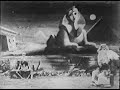 2url.org - Download Old and New Movies! An Egyptian prince has lost his beloved wife and he has sought a dervish who dwells at the base of the sphinx. The prince promises him a vast fortune if the dervish will only give him the opportunity of gazing once more upon the features of his wife. The dervish accepts the offer. He brings in from a neighboring tomb the receptacle containing the remains of the princess. He opens it and removes the skeleton, which he places upon the ground close beside him. Then, turning to the moon and raising his arms outstretched toward it, he invokes the moon to give back life to her who is no more. The skeleton begins to move about, becomes animated, and arises. The dervish puts it upon a bench and covers it with a white linen; a masque conceals its ghostly face. At a second invocation the skeleton begins again to move, arises, and performs a weird dance. In performing its contortions it partly disappears in the ground. While performing its feats it increases gradually in size, its neck assuming enormous proportions, much to the horror of the prince, who fails to see in this grotesque character the wife whom he has lost. The dance ceases. The dervish throws a veil over the hideous creature. Then appear the real princess as she was when her husband possessed her. The prince darts forward to take her into his arms to give her a last kiss, but the dervish stops him, wraps the young lady in the veil and throws her into the arms of the prince. When <b>...</b>