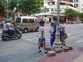 school kids crossing the road in kaiping, whereas the bicycle guy goes under the red and white band