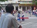 school kids crossing the road in kaiping, whereas the bicycle guy goes under the red and white band