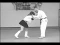 Oriental woman dressed in school girl outfit uses judo on a bigger man.