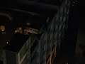 Stunt Batman repelling down a parking garage in chicago