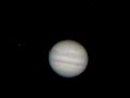 Jupiter through a telescope. Io disappears behind Jupiter