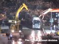 Cranes working at night filling dump trucks
