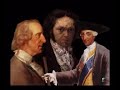 http://www.artehistoria.com/artesp/videos/276.htm

goya conoce hacia el a�o 1783 al infante don luis, hermano menor del rey carlos iii. en el verano del a�o siguiente, el pintor se traslada a arenas de san pedro, donde pintar� este soberbio retrato familiar. 
en el centro de la composici�n se encuentra do�a mar�a teresa de vallabriga, esposa del infante, siendo peinada por su peluquero de confianza. a su derecha, se sit�a don luis, de perfil, ensimismado con las cartas que se depositan sobre la mesa, iluminada con una vela. tras �l y tambi�n de perfil encontramos a su hijo, don luis mar�a de borb�n y vallabriga, m�s tarde cardenal y arzobispo de toledo. a su lado la peque�a mar�a teresa de borb�n y vallabriga, por la que goya sent�a especial predilecci�n. esta ni�a se casar�a m�s adelante con godoy y fue retratada por el pintor en un soberbio lienzo cuando estaba embarazada. 
en la zona izquierda de la composici�n, y en primer plano, se ubica el pintor, de espaldas y ante un gran lienzo. junto a goya, se hallan dos damas de la peque�a corte de los infantes, portando en sus manos una bandeja y un joyero. 
en la zona de la derecha de la escena vemos un grupo de hombres, amigos y miembros de la corte de don luis, acompa�ados de una ama de cr�a que sujeta a una ni�a en sus brazos. 
la composici�n se organiza a trav�s de dos diagonales que se cruzan en el centro, lugar ocupado por do�a mar�a teresa, indicando de esta manera el importante papel de la dama en el entorno familiar y social del infante. 
goya ha individualizado perfectamente cada uno de los personajes, creando un magn�fico ambiente a trav�s de la luz, ambiente distendido como deb�an ser las veladas de don luis. las calidades de telas y adornos han sido representadas de manera exquisita, abri�ndose el maestro la puerta como retratista de corte.