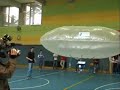 Progetto Dirigibile ARIA. Maturità 2006.
Il Primo Volo.
Il dirigibile viene fatto volare per la palestra.
L'equilibrio è stato raggiunto zavorrando il pallone con delle bottigliette d'acqua opportunamente riempite.
Nonostante i movimenti siano lenti (motori non molto potenti) si sono ottenuti risultati ottimi.
Il controllo avviene tramite JoyPad, mentre sul computer si possono vedere i valori dei sensori e l'orientamento del velivolo (grazie alla bussola elettronica).
Sulla tv invece si può osservare l'immagine della videocamera.
Il programma di gestione del velivolo sul pc è stato realizzato in visual basic, mentre i programmi interni dei microcontrollori in 
