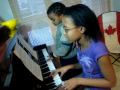 Keza Ruzima practicing piano with little brother Joshua