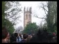 the magadalen college boys choir singing their traditional madrigals (or whatever) at the top the college tower, seen from the other side of magdalen bridge, shortly after sunrise  on 1 may 2005 in oxford.