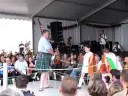 mark mckenzie participating in the kitchen piping competition at lorient during the festival interceltique.  he has help from 2 delightful young girls who dance and provide him with fuel when he slows down