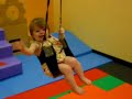 Katie swinging down the zipline at Gymboree with her friends