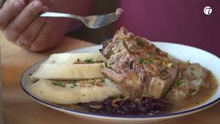 Saftiger Schweinebraten, serviert an traditionellem Kraut und zweierlei Knödel