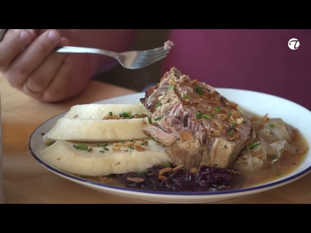 Saftiger Schweinebraten, serviert an traditionellem Kraut und zweierlei Knödel
