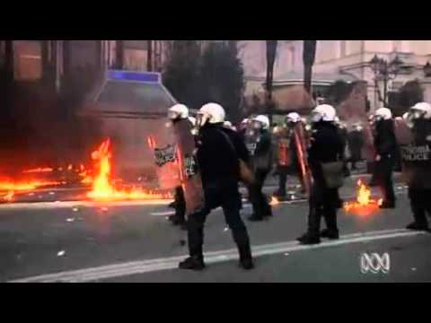sparmaßnahmen - Buildings burned in central Athens this morning after black-masked protesters fought Greek police outside parliament, while inside MPs looked set to defy the...