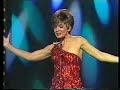shirley bassey with three james bond songs from the palladium 1987. a wonderful rendition of 'view to a kill' (duran, duran: that's how it's done).

'view to a kill' is playback, which is very exceptional for shirley. after that a great live rendition of goldfinger/diamonds are forever.

between the two songs shirley is presented a golden video by jimmy tarbuck for her 1985 live performance in cardiff's saint david's hall.





lyrics a view to a kill:

meeting you with a view to a kill face to face in secret places feel the chill
nightfall covers me but you know the plans i'm making
still over sea could it be the whole earth opening wide
a sacred why a mystery gaping inside the weekends why until we

dance into the fire that fatal kiss is all we need
dance into the fire to fatal sounds of broken dreams
dance into the fire that fatal kiss is all we need dance into the fire

choice for you is the view to a kill between the shades assasination standing still
first crystal tears fall of snowflakes on your body
first time in years to drench your skin with lovers rosy stain
a chance to find a phoenix for the flame a chance to die but can we
dance into the fire that fatal kiss is all we need
dance into the fire to fatal sounds of broken dreams
dance into the fire that fatal kiss is all we need
dance into the fire when all we see is the view to a kill.

lyrics goldfinger:

golfinger,
he's the man, the man with the midas touch
a spider's touch

such a cold finger
beckons you to enter his web of sin
but don't go in

golden words he will pour in your ear
but his lies can't disguise what you fear
for a golden girl knows when he's kissed her
it's the kiss of death ...

from mister goldfinger
pretty girl, beware of his heart of gold
this heart is cold

golden words he will pour in your ear 
but his lies can't disguise what you fear
for a golden girl knows when he's kissed her
it's the kiss of death ...

from mister goldfinger
pretty girl, beware of his heart of gold
this heart is cold
he loves only gold
only gold
he loves gold
he loves only gold
only gold
he loves gold.


goldfinger 
music by john barry, lyrics by leslie bricusse and anthony newley   

recorded august 20th 1964 and released in 1964 on soundtrack album, and on many singles and eps. the uk single was release in september 1964 (db 7360) and the us single followed in december 1964 (ua 790). both the original mono single version and the stereo soundtrack version are available together on the 1995 us collection goldsinger - the best of shirley bassey. the stereo soundtrack version is also available on many collections.

goldfinger is the song which shirley bassey is most known for. as a result it is performed at most concerts, and is available performed on most live albums and videos and dvds.

new studio recordings were released on the 1984 album i am what i am and on the 1995 album shirley bassey sings the movies. another studio recording was released in 1992 on the bassey sings bond album.

a remix of the 1964 single version has been done by the propellerheads in 2000 and released on the remix album...diamonds are forever.