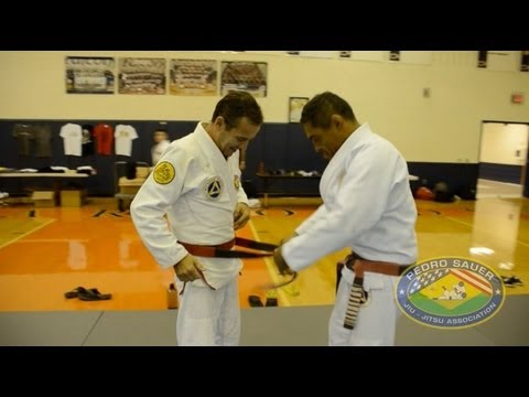 Rickson Gracie putting Red/Black belt on Pedro Sauer