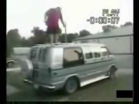Fat guy tries to jump van and falls off.