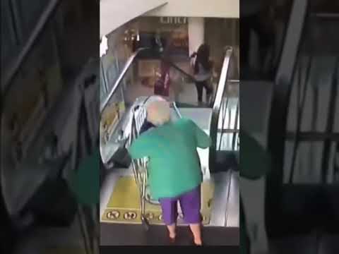 Starsza pani wjeżdża wózkiem na ruchome schody. Spadając robi salto