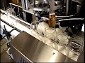 Machine automatically cuts wick to size, crimps tab to wick, inserts glue in container, centers and inserts one or two wicks.   Machine manufactured in the USA by JBN Design.   www.jbndesign.com