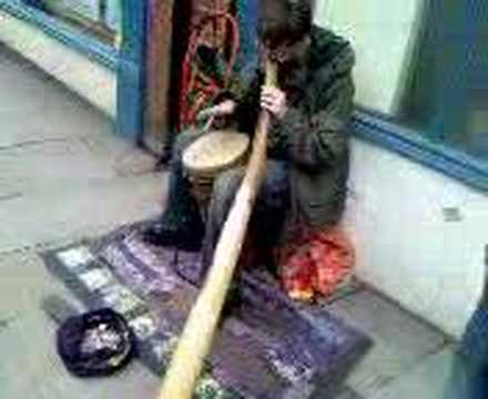 a guy playing hisdidgeridoo  in ...