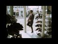 Mr Bean gets a stone in his shoe. When he takes it off to get rid of the stone he puts his shoe on top of a car that drives off so he has to hop around to get it back. From Mr Bean Goes to Town.