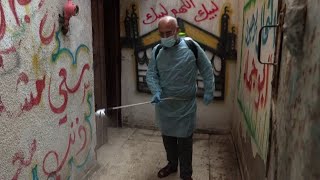 عاملون في مجال الصحة يعقمون الازقة في مخيم الشاطئ في قطاع غزة خشية انتشار فيروس كورونا