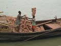 Hard labour, guy stacking 20 bricks on his head