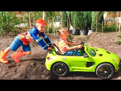 Nikita ride on children's car and stuck in the ground Vlad tows on the tractor