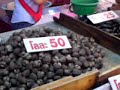 Tal leidt ons rond op een lokale markt in Thailand. Ze legt wat uit over vlees en garnalen.