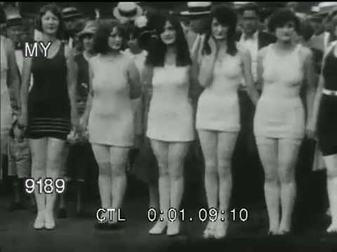 bathing suits women - Footage of 1920s women in bathing suits and swimwear, in various activities: riding on a train locomotive; dancing in a tropical garden; playing with beach b...